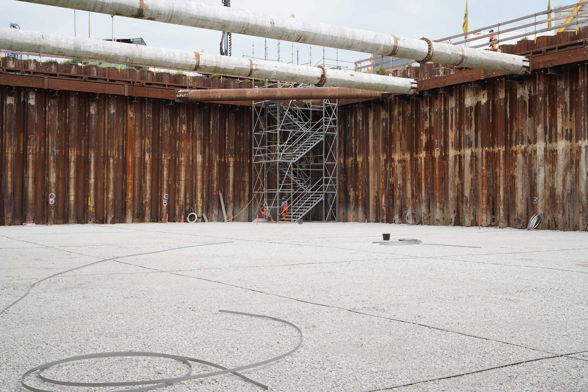 Gravel is located at the bottom of the construction pit of the ventilation building at Konrad 2. Sheetboard walls frame the construction pit. They are supported by transverse struts.