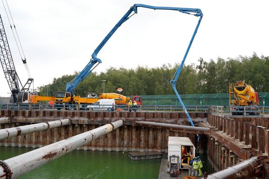 Betonmischfahrzeuge versorgen eien Betonpumpe mit Fertigbeton