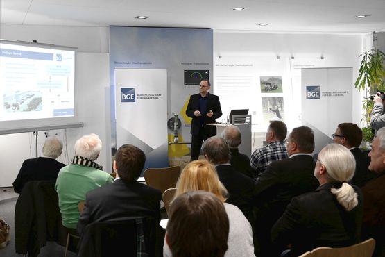 "Betrifft: Konrad"-Veranstaltung über aktuelle Entwicklungen Der Referent zeigt in der Infostelle Konrad den sitzenden Bürgern seine Präsentation