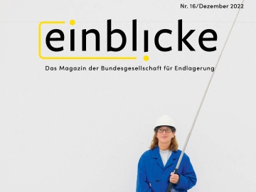 Das Cover des Einblicke Magazins Nummer 16 zeigt eine Frau mit weißem Helm, langen rotbraunen Haaren und Brille in einem blauen Arbeitskittel. In der Hand hält sie ein Messgerät, das an eine Angel erinnert.