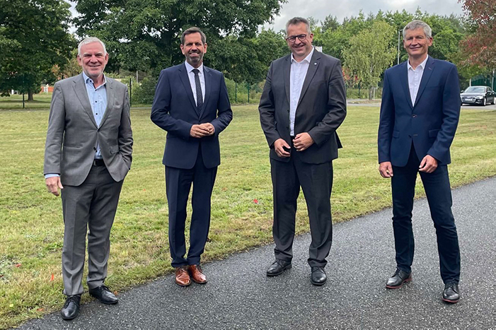 Four men are standing next to each other