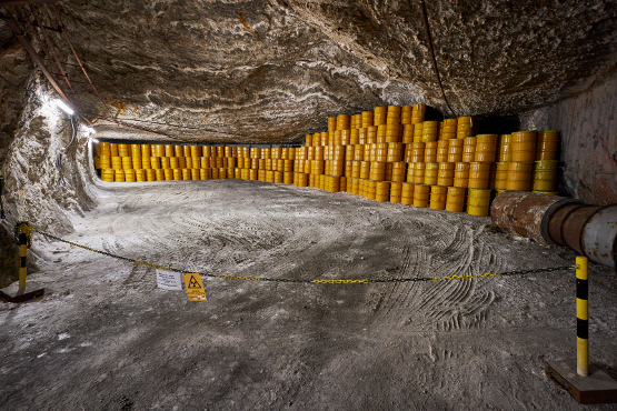 Gelbe Fässer stehen gestapelt und nebeneinander gereiht in einer Abbaukammer.