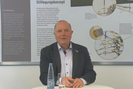 Werksleiter Frank-Holger bei seinem Vortrag zum Betriebsgeschen im Endlager Morsleben. Ein Mann steht an einem Stehtisch vor einer Schautafel