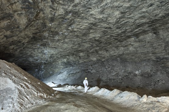 Eine Person steht in einer ehemaligen Abbaukammer für Steinsalz. Die Kammer ist sehr groß.