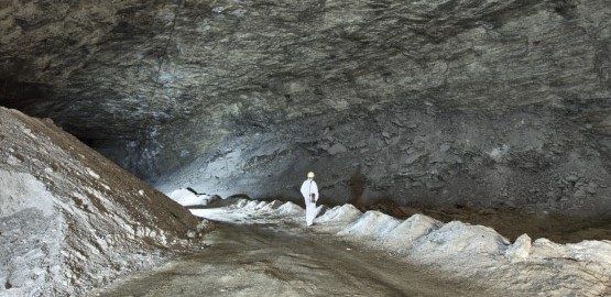 A person is standing in a former mining chamber at the morsleben repository. The chamber idst very large. Link to page "Stability at Morsleben - from mine to repository"