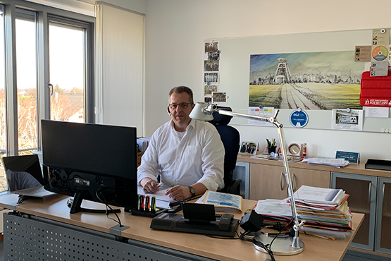 Mann sitzt an einem Schreibtisch in einem Büro